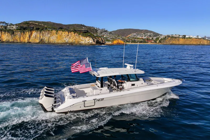 Slide: The Image of A 2026 HCB 42 Lujo cruising on the sea, with an American flag at the stern. - 4