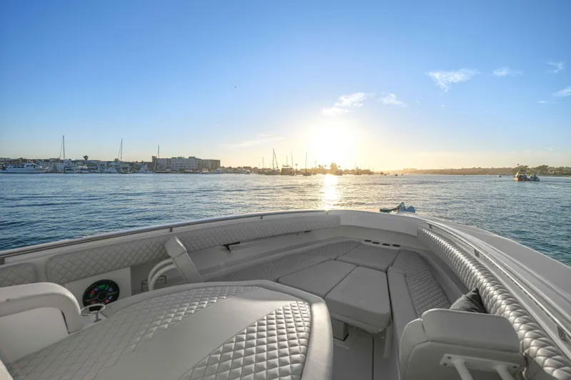 Slide: The Image of The image shows the bow of an HCB 42 Lujo with cushioned seating, overlooking a sunset on the water. - 35