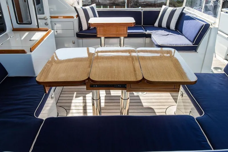 Slide: The Image of Luxurious 2004 Ta Chiao Custom Pilothouse Cutter interior with elegant wood and navy seating. - 10