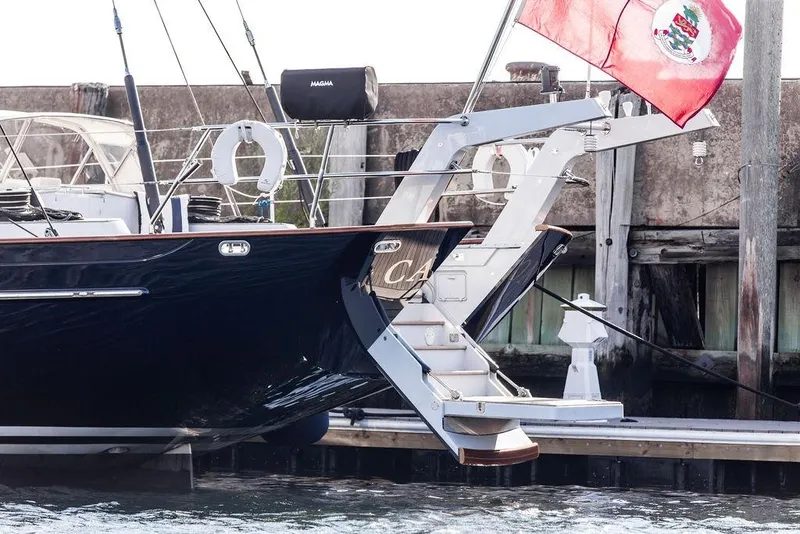 Slide: The Image of 2004 Ta Chiao Custom Pilothouse Cutter docked with red flag and boarding ladder. - 55