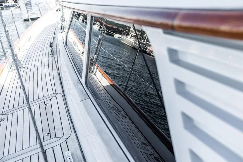 Slide: The Image of 2004 Ta Chiao Custom Pilothouse Cutter deck with sleek wood finish and reflective windows. - 14