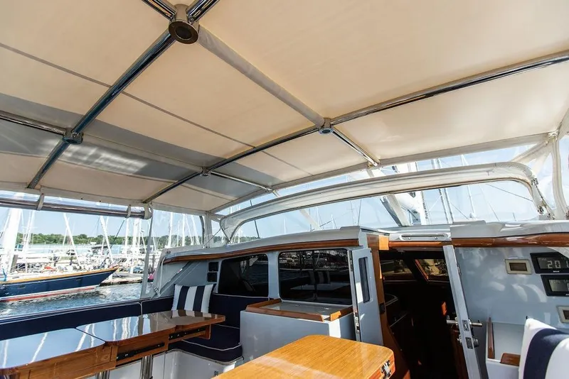 Slide: The Image of 2004 Ta Chiao Custom Pilothouse Cutter interior with seating and table under canopy. - 12