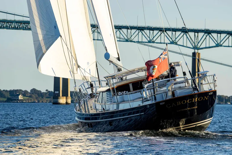 Slide: The Image of 2004 Ta Chiao Custom Pilothouse Cutter sailing under a bridge with full sails. - 2