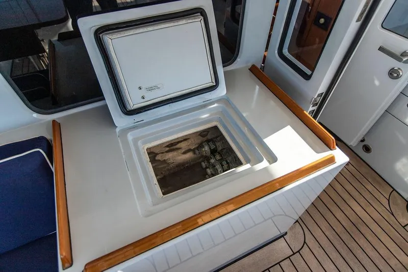 Slide: The Image of 2004 Ta Chiao Custom Pilothouse Cutter interior with open storage compartment on deck. - 13