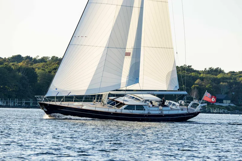 Slide: The Image of 2004 Ta Chiao Custom Pilothouse Cutter sailing on calm waters near a wooded shoreline. - 60