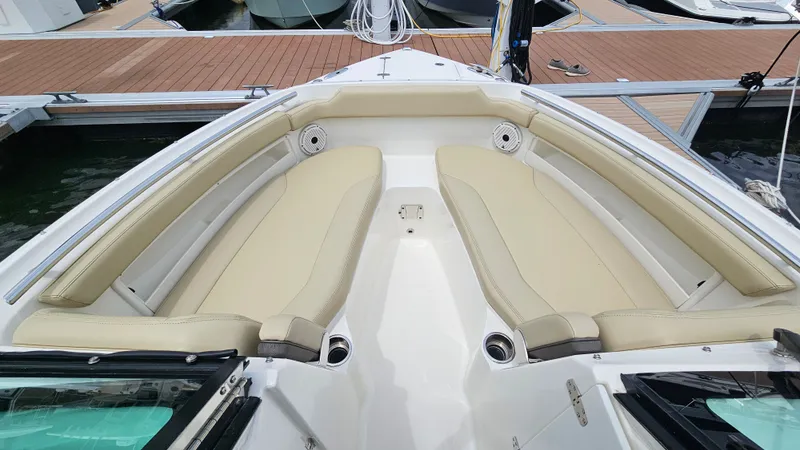 Slide: The Image of The image shows the bow of a 2021 Pursuit DC 266 Dual Console boat with beige seating. - 38