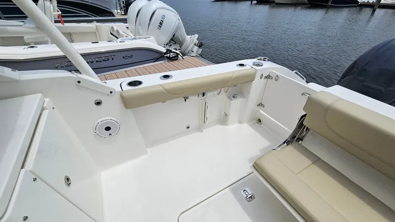 Slide: The Image of The image shows the cockpit of a 2021 Pursuit DC 266 Dual Console boat with beige seating. - 24