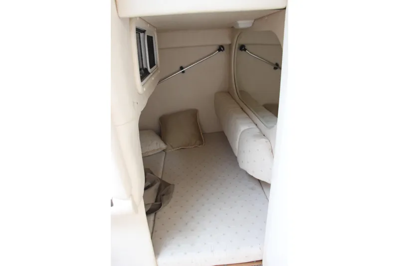 Slide: The Image of Interior cabin of 2002 Sea Ray Sundancer 260, featuring cozy sleeping area with cushions. - 10