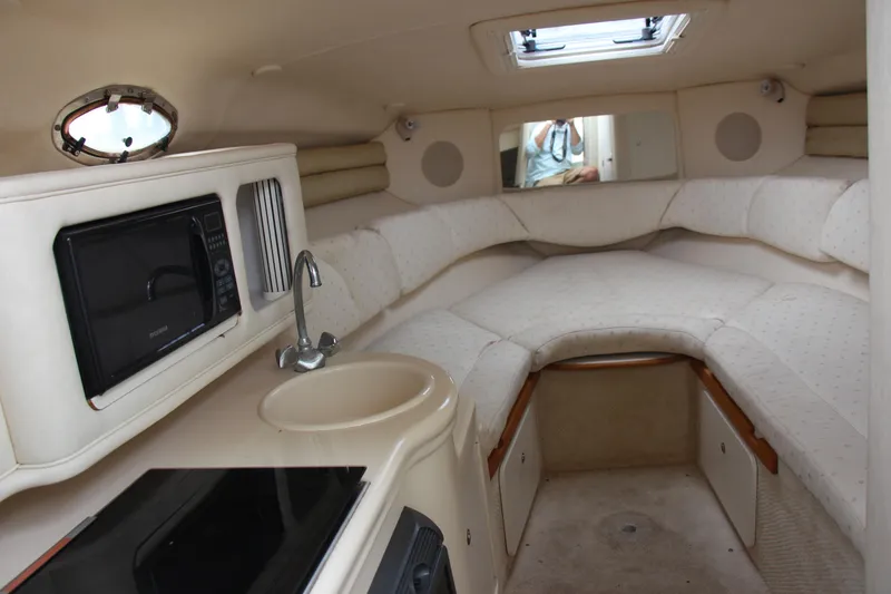 Slide: The Image of Interior of 2002 Sea Ray Sundancer 260, featuring cozy seating, kitchenette, and modern amenities. - 9