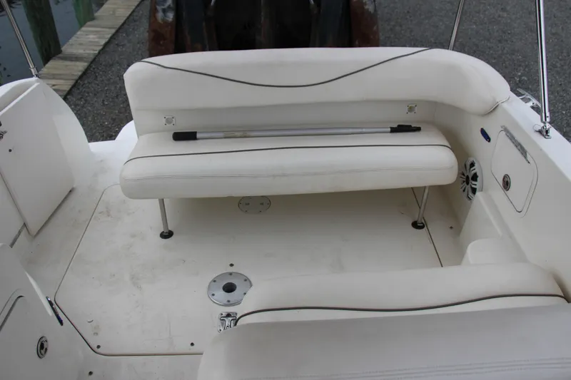 Slide: The Image of 2002 Sea Ray Sundancer 260 boat interior with white seating and storage compartments. - 5
