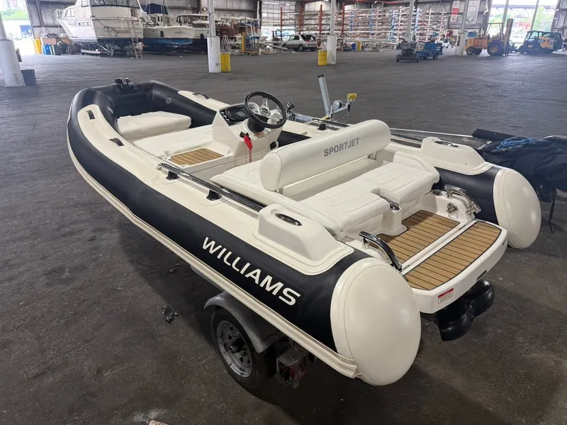 The Image of A 2019 Williams Jet Tenders 395 Sport Jet in a warehouse. It features a sleek design with white and black accents. - 0