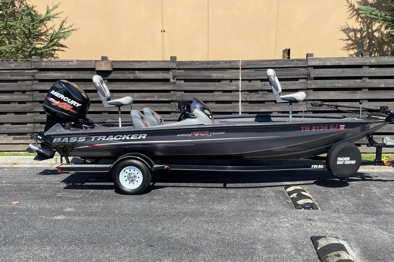 The Image of 2014 Tracker Pro Team 190 TX bass boat with Mercury engine, parked on a trailer. - 1