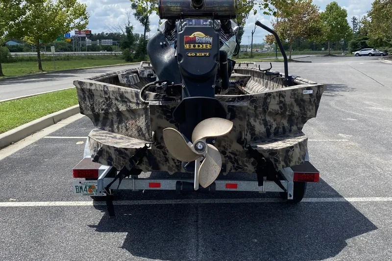 Slide: The Image of 2022 Havoc 1860 DBST boat with camouflage design and outboard motor in parking lot. - 3