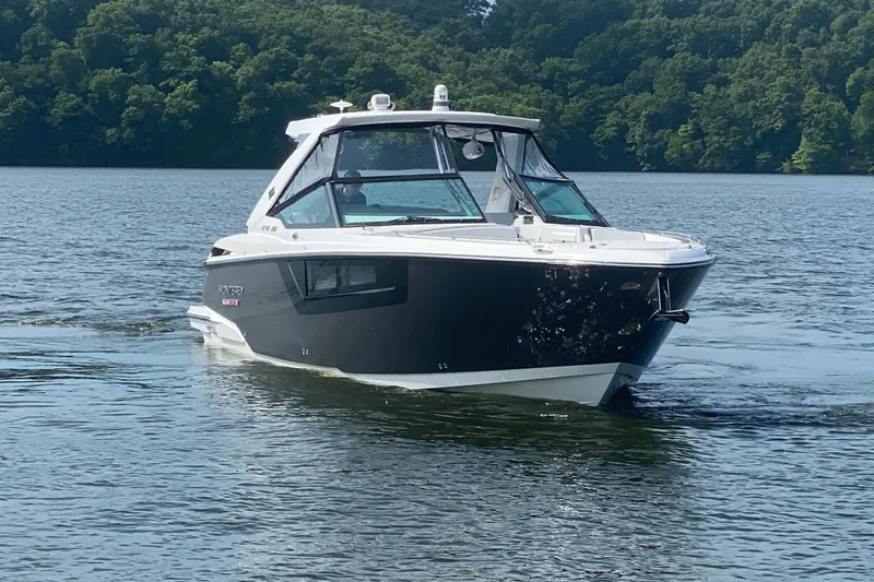 Slide: The Image of 2023 Monterey 378SS Super Sport boat cruising on a serene lake with lush green trees. - 4