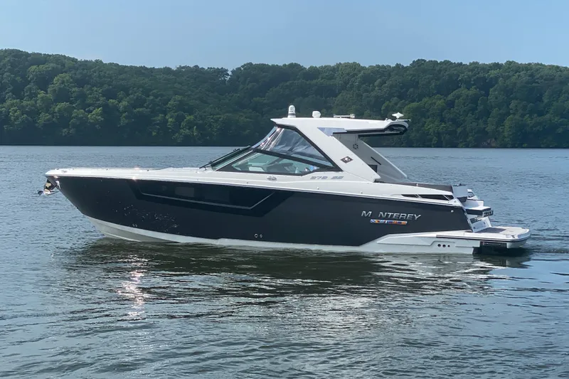 Slide: The Image of 2023 Monterey 378SS Super Sport boat on a serene lake with forested background. - 6