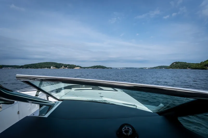 Slide: The Image of 2023 Monterey 378SS Super Sport cruising on a scenic lake under a clear blue sky. - 18