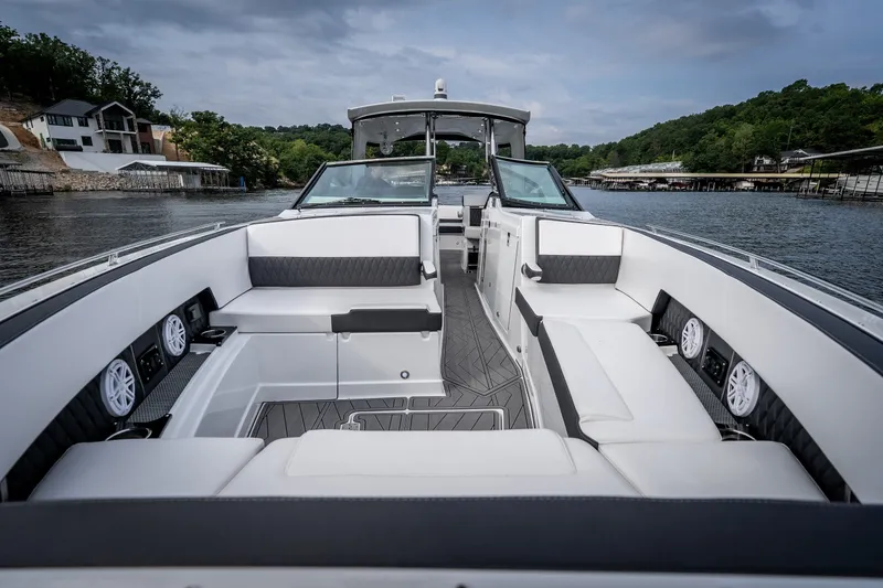 Slide: The Image of 2023 Monterey 378SS Super Sport boat interior with luxurious seating on a scenic lake. - 28