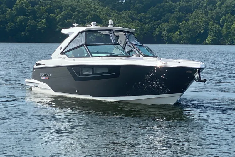 Slide: The Image of 2023 Monterey 378SS Super Sport boat cruising on a serene lake with lush green trees. - 3