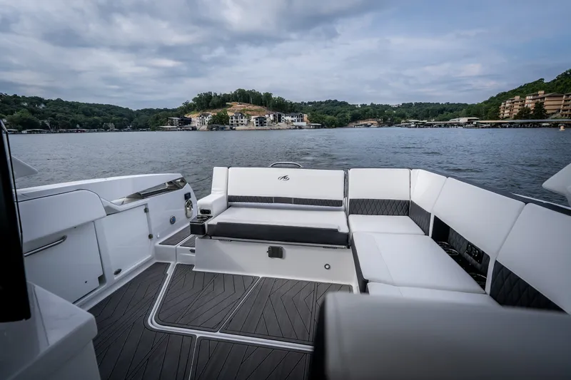 Slide: The Image of 2023 Monterey 378SS Super Sport boat interior with luxurious seating on a scenic lake. - 32
