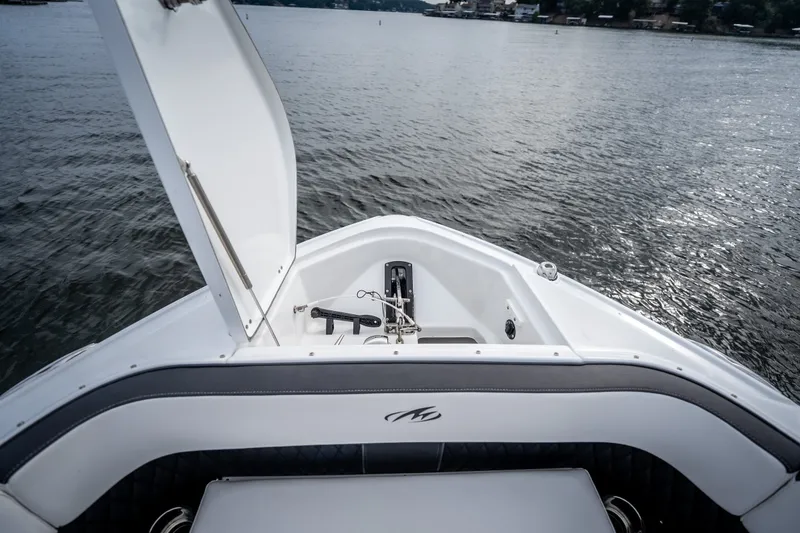 Slide: The Image of 2023 Monterey 378SS Super Sport boat bow with open storage compartment on calm water. - 27