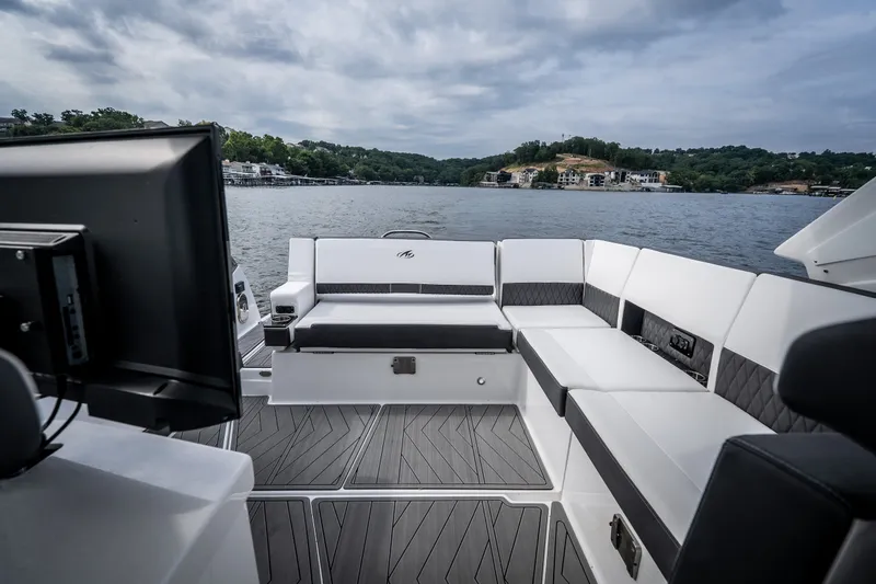 Slide: The Image of 2023 Monterey 378SS Super Sport boat interior with luxurious seating on a scenic lake. - 33