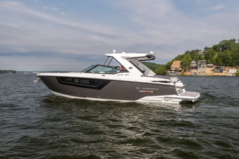 Slide: The Image of 2023 Monterey 378SS Super Sport boat cruising on a scenic lake with houses in the background. - 5