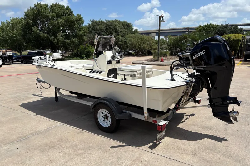 Slide: The Image of 2021 Mako Pro Skiff 15 CC boat on trailer, parked outdoors under a clear sky. - 6