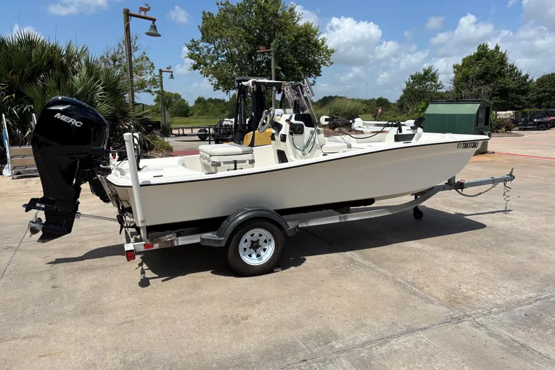 Slide: The Image of 2021 Mako Pro Skiff 15 CC boat on trailer, parked outdoors under a clear sky. - 9