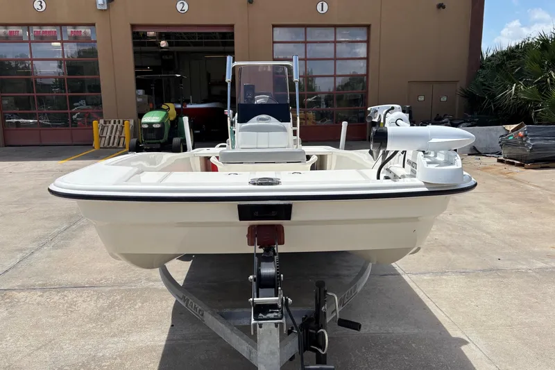 Slide: The Image of 2021 Mako Pro Skiff 15 CC boat on trailer, parked outside a garage. - 63