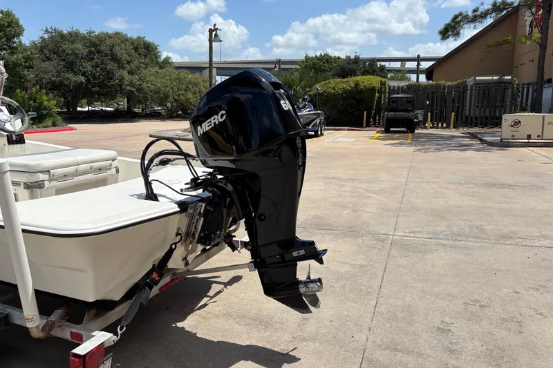Slide: The Image of 2021 Mako Pro Skiff 15 CC with Mercury outboard motor in a parking lot. - 8