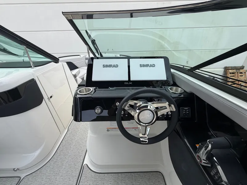 Slide: The Image of The image shows the cockpit of a Sea Ray SLX 280 Outboard with a modern helm and Simrad screens. - 20