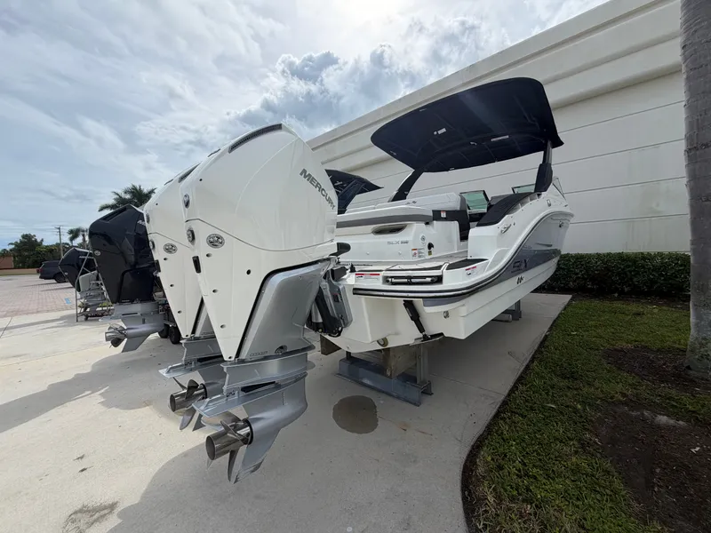 Slide: The Image of A 2027 Sea Ray SLX 280 Outboard with dual outboard engines, parked on a concrete lot. - 2