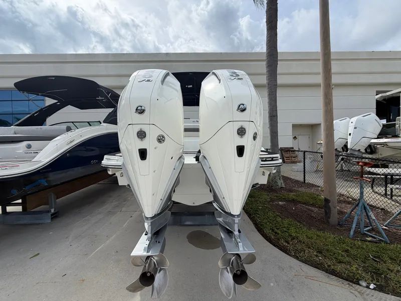 Slide: The Image of Two powerful outboard engines are mounted on the stern of a Sea Ray SLX 280, parked on concrete. - 3