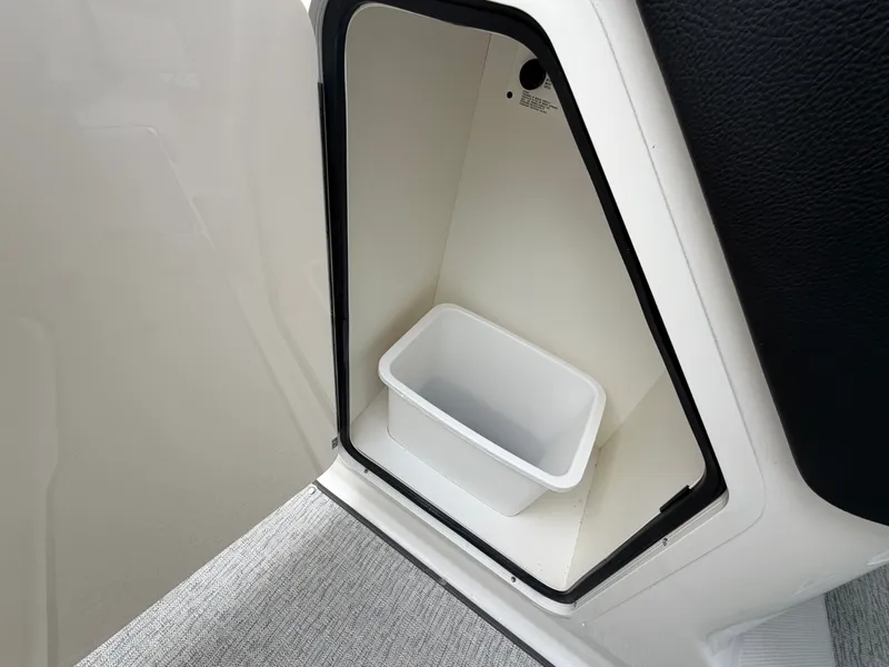 Slide: The Image of An open storage compartment with a white bin inside. - 24