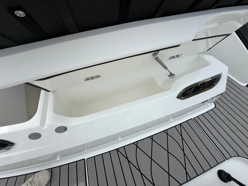 Slide: The Image of An open storage compartment on a Sea Ray SLX 280 Outboard boat, featuring gray flooring. - 9