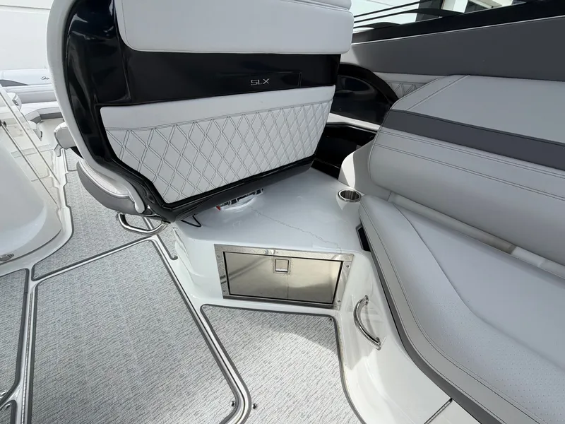 Slide: The Image of The image shows the interior of a Sea Ray SLX 280 Outboard with sleek, upholstered seating and a small storage compartment. - 15