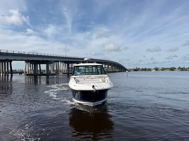 Slide: The Image of A 2027 Sea Ray Sundancer 320 Outboard cruising on a calm river beneath a bridge. - 5