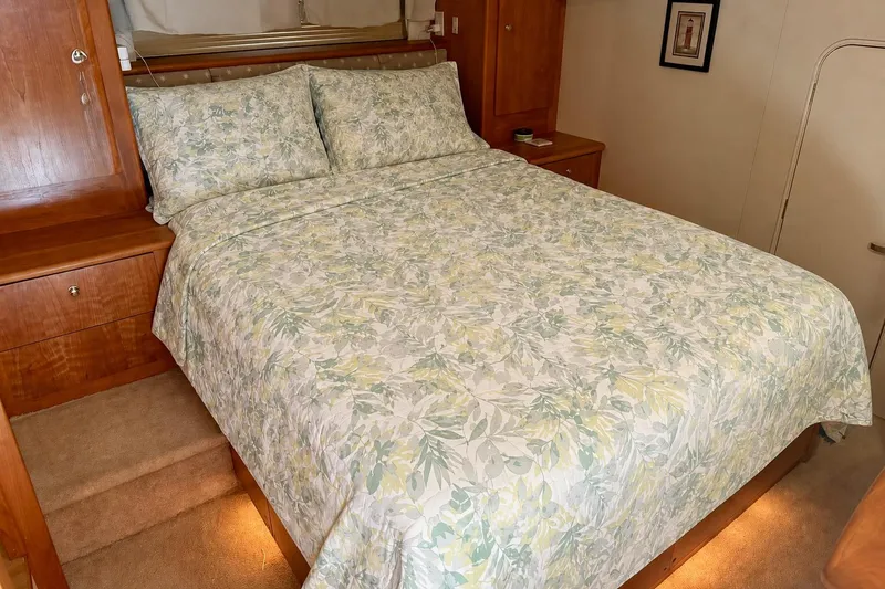 Slide: The Image of Cozy bedroom in 2000 Silverton 453 Motor Yacht with floral bedding and wooden cabinetry. - 24