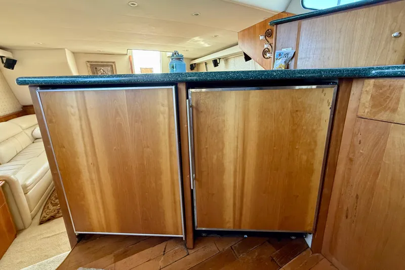 Slide: The Image of Interior of 2000 Silverton 453 Motor Yacht with wooden cabinetry and black countertop. - 14