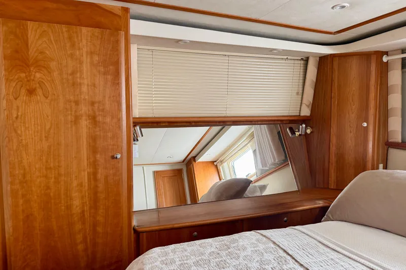 Slide: The Image of Interior of 2000 Silverton 453 Motor Yacht with wooden cabinetry and cozy bedding. - 21