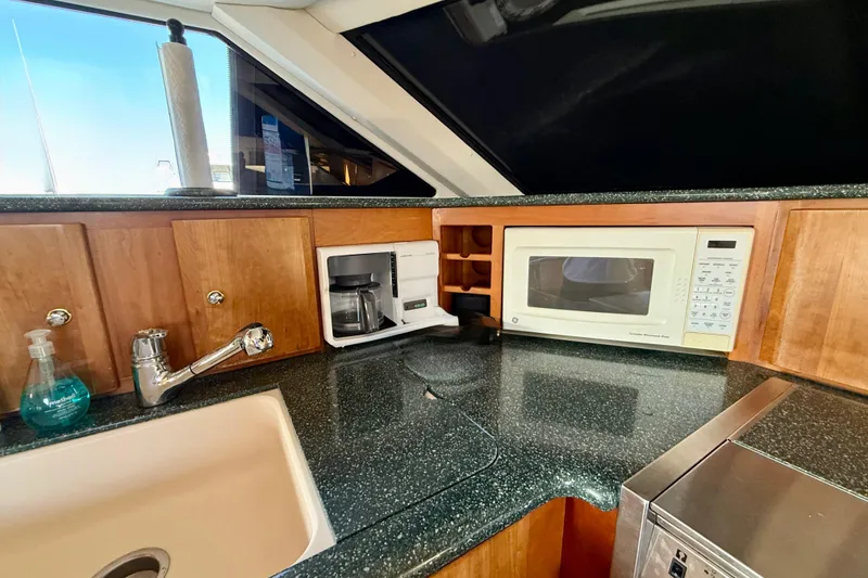 Slide: The Image of Kitchen area of 2000 Silverton 453 Motor Yacht with sink, microwave, and coffee maker. - 15