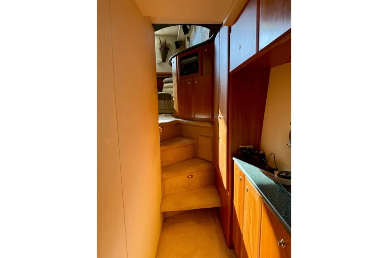 Slide: The Image of Interior view of 2000 Silverton 453 Motor Yacht, featuring wooden cabinetry and carpeted stairs. - 23