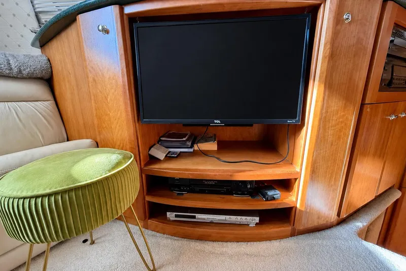 Slide: The Image of Interior of 2000 Silverton 453 Motor Yacht with TV and green stool. - 11