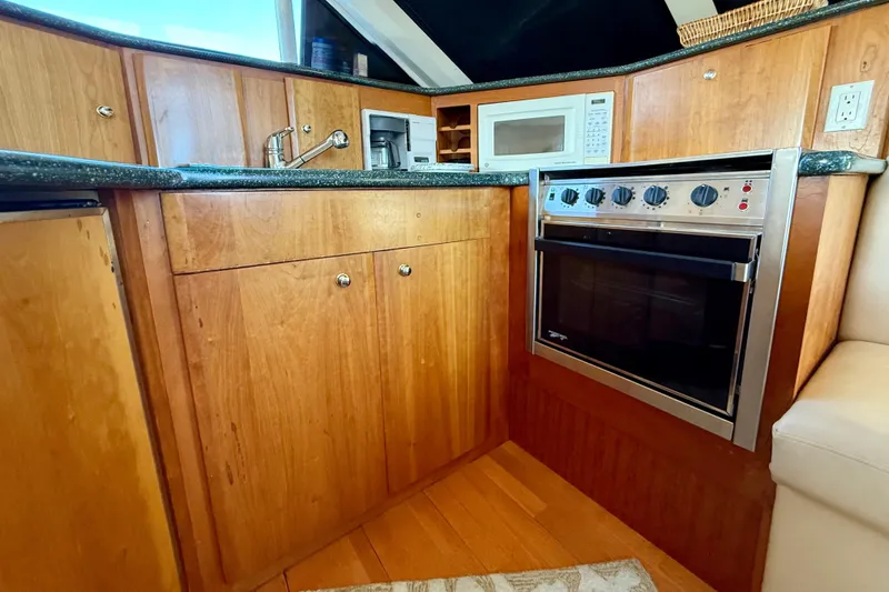 Slide: The Image of Kitchen area of a 2000 Silverton 453 Motor Yacht with wood cabinetry and modern appliances. - 13