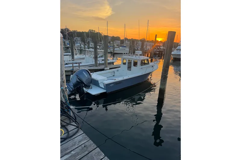 The Image of 2023 Parker 2320 SL Sport Cabin boat docked at sunset in a marina. - 1