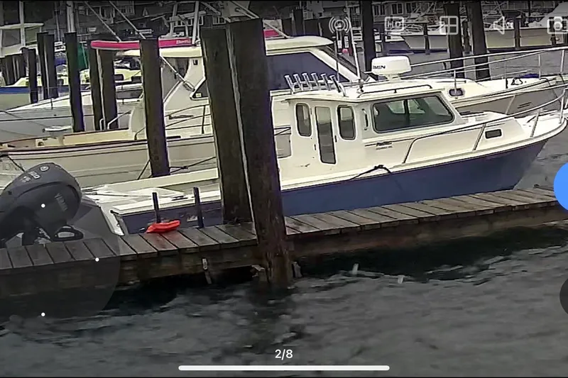 Slide: The Image of 2023 Parker 2320 SL Sport Cabin boat docked at a marina. - 3