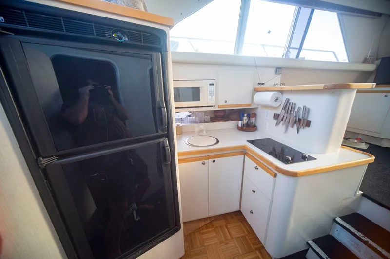 Slide: The Image of 1996 CRUISERS YACHTS 3580 Flybridge kitchen with fridge, microwave, and stovetop. - 44