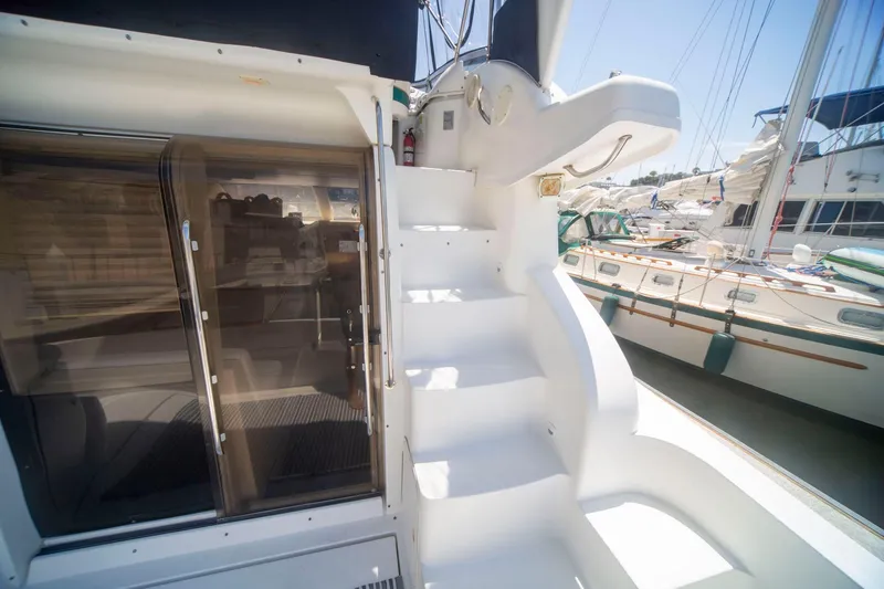Slide: The Image of 1996 CRUISERS YACHTS 3580 Flybridge with white stairs and glass doors at marina. - 19