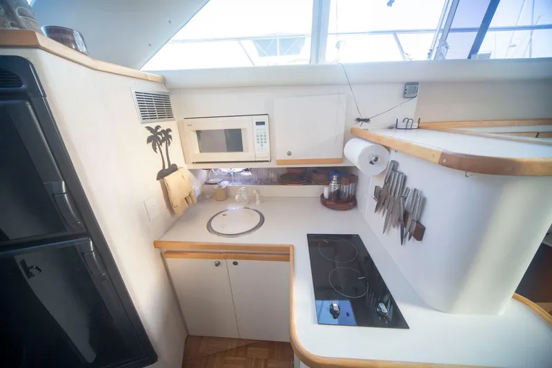 Slide: The Image of 1996 CRUISERS YACHTS 3580 Flybridge kitchen with stove, microwave, and knife set. - 47