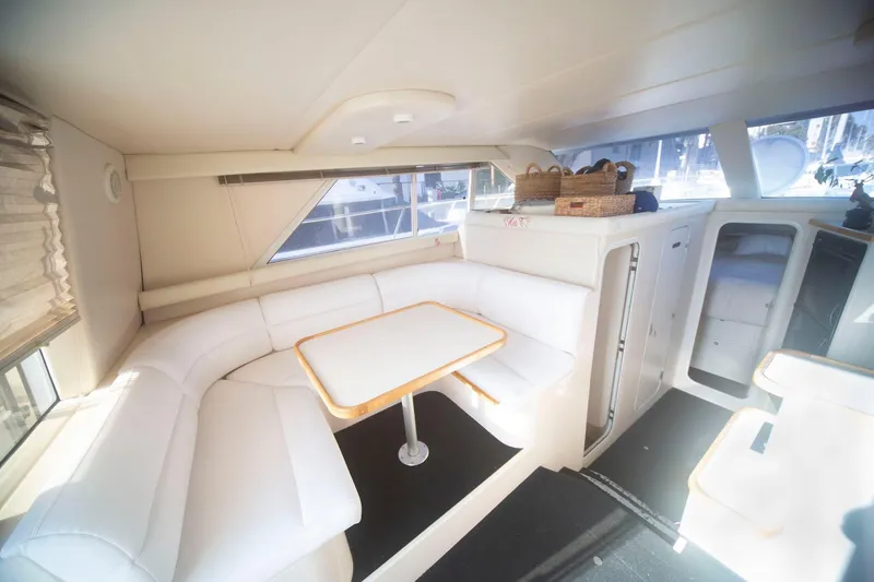 Slide: The Image of Luxurious interior of 1996 CRUISERS YACHTS 3580 Flybridge with white seating and dining area. - 49